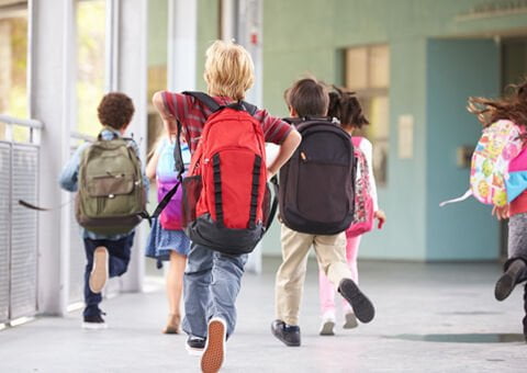 Barn som springer till skolan.