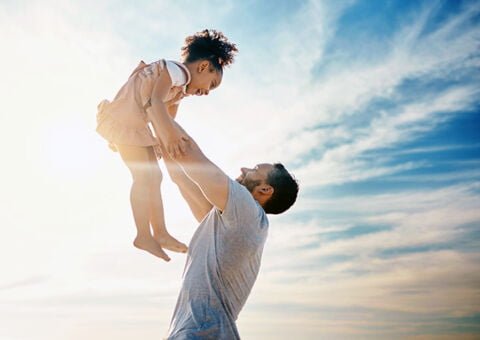 Man som lyfter barn mot himlen_600x424