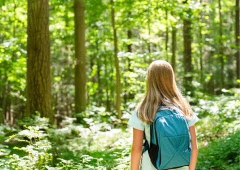 Flicka med pollenallergi går i skog